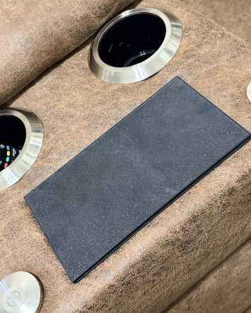 Black SabotTX wireless charging tray cover installed on a compatible La-Z-Boy recliner console beside cup holders.